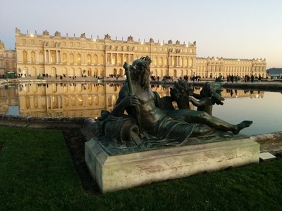 [Versailles au coucher du soleil: le château reflété sur le bassin nord]